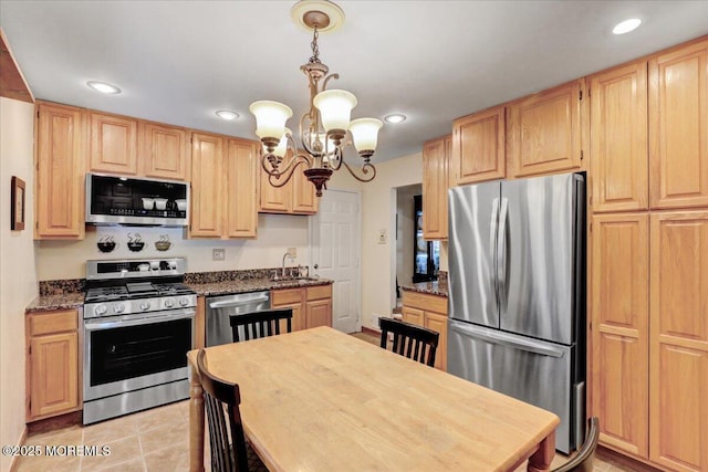 kitchen with a sink, appliances with stainless steel finishes, an inviting chandelier, and light brown cabinetry
