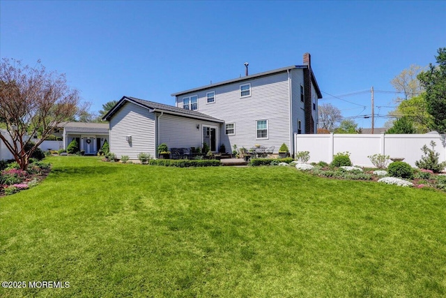 rear view of property with a lawn, fence, and a chimney