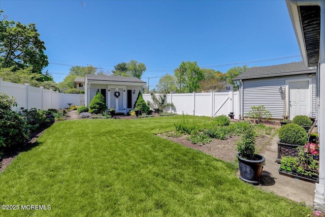 view of yard featuring a fenced backyard, an outbuilding, and a vegetable garden
