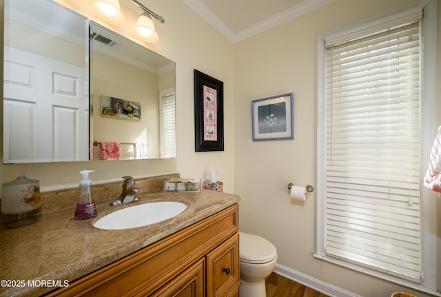 bathroom with vanity, toilet, baseboards, wood finished floors, and ornamental molding