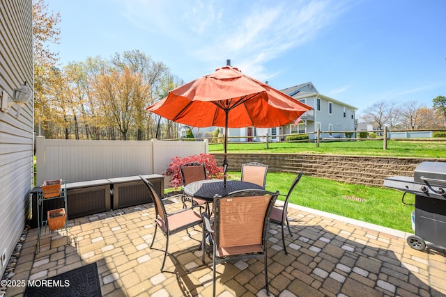 view of patio featuring outdoor dining area, a fenced backyard, and a grill