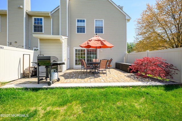 back of house featuring a patio, a fenced backyard, a yard, and a chimney