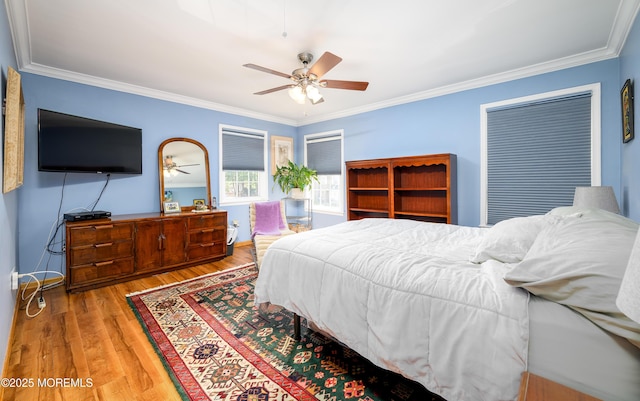 bedroom featuring ceiling fan, ornamental molding, and wood finished floors