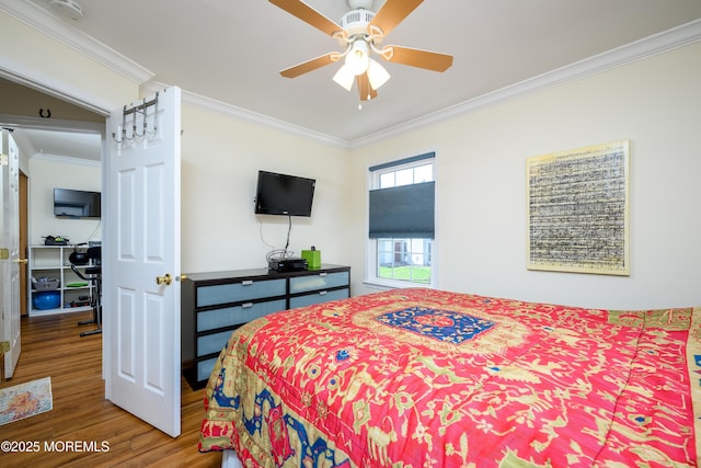 bedroom with ceiling fan, ornamental molding, and wood finished floors