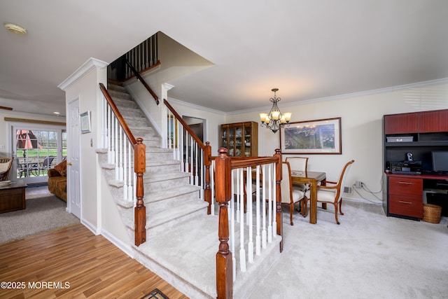 stairway featuring baseboards, ornamental molding, carpet floors, and a chandelier