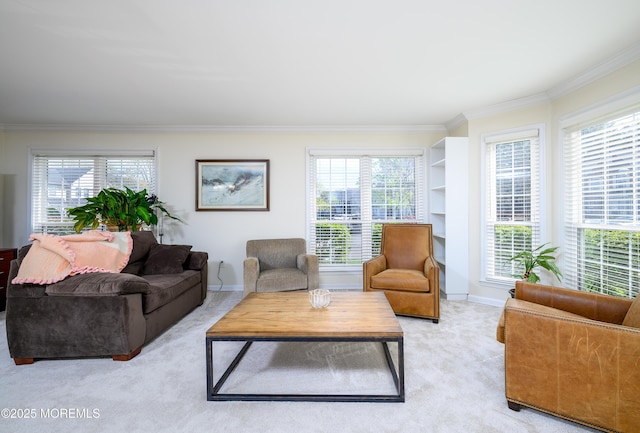 living area featuring plenty of natural light, baseboards, ornamental molding, and light carpet