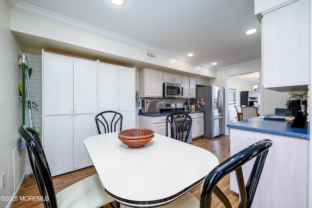 dining room featuring crown molding, recessed lighting, wood finished floors, and visible vents