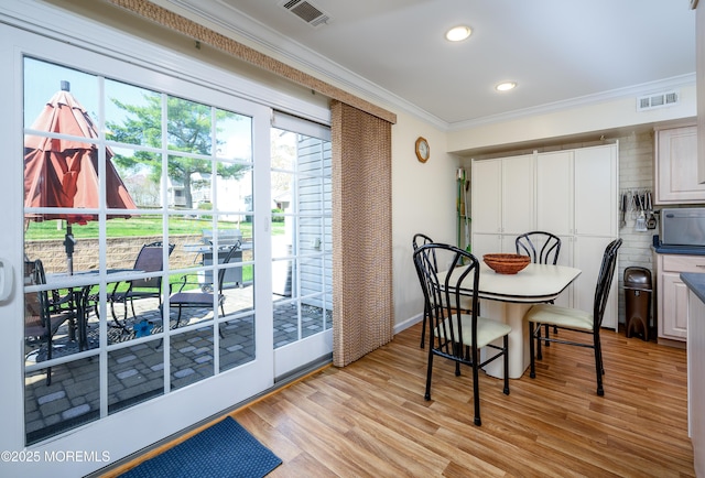 dining space with crown molding, recessed lighting, visible vents, and light wood-style flooring
