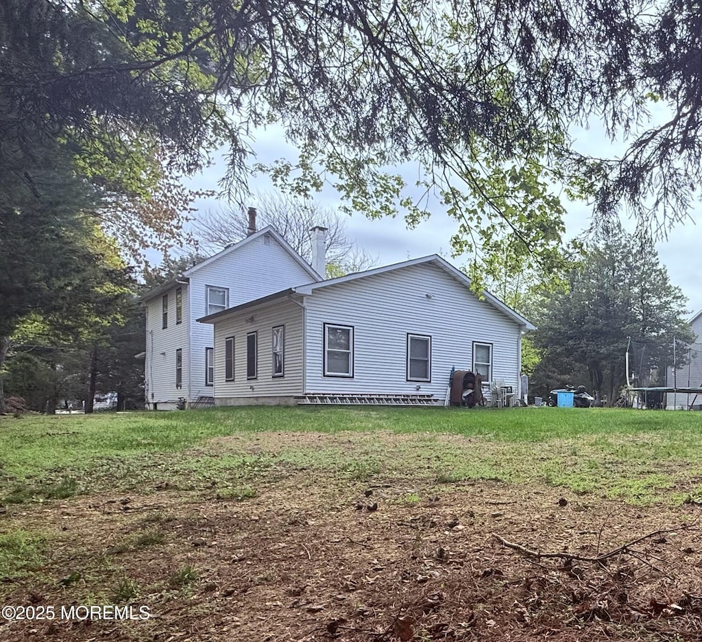 479 Line Rd, Matawan, NJ 07747 - back of property with a lawn, a chimney, and a trampoline