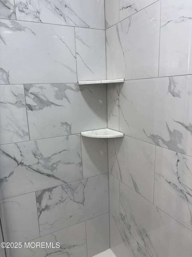 interior details featuring a tile shower