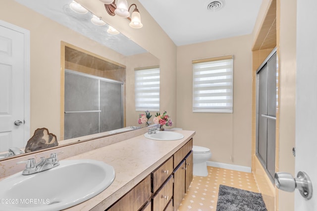 full bath with tile patterned floors, a sink, a shower with door, and visible vents