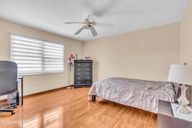 bedroom with wood finished floors, a ceiling fan, and baseboards