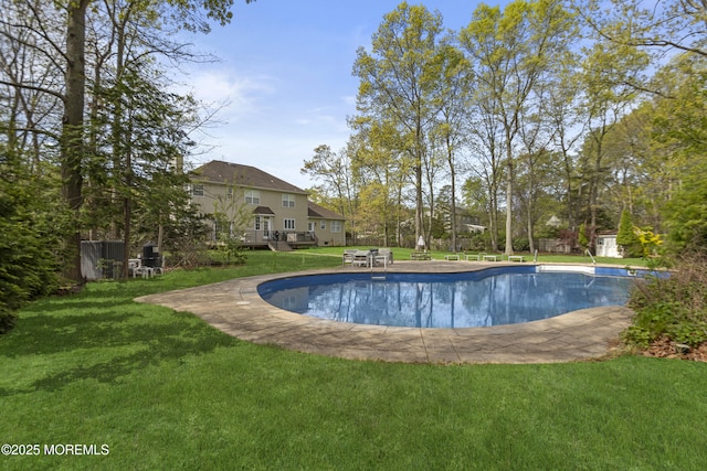outdoor pool with a lawn and an outbuilding