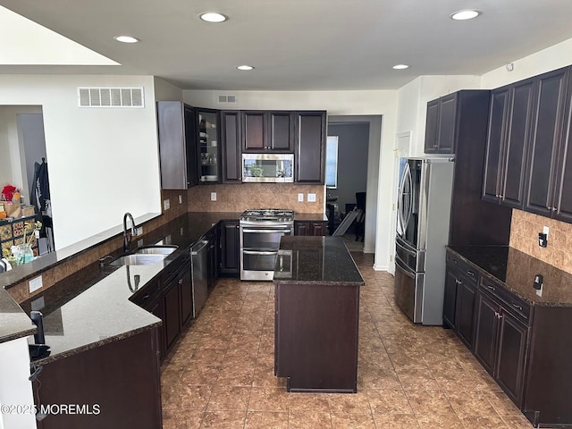 4 Christopher Dr, Howell, NJ 07731 - kitchen with dark stone countertops, a sink, decorative backsplash, stainless steel appliances, and visible vents