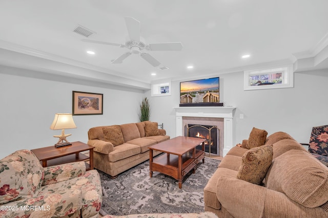 living area with visible vents, ornamental molding, a fireplace, ceiling fan, and recessed lighting
