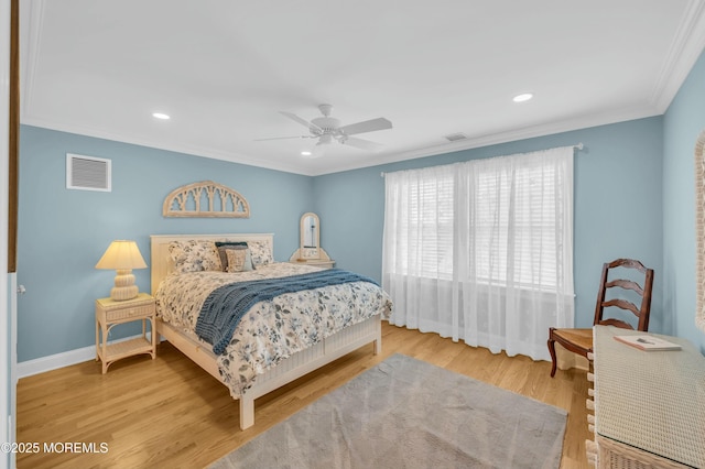 bedroom featuring visible vents, crown molding, wood finished floors, baseboards, and ceiling fan