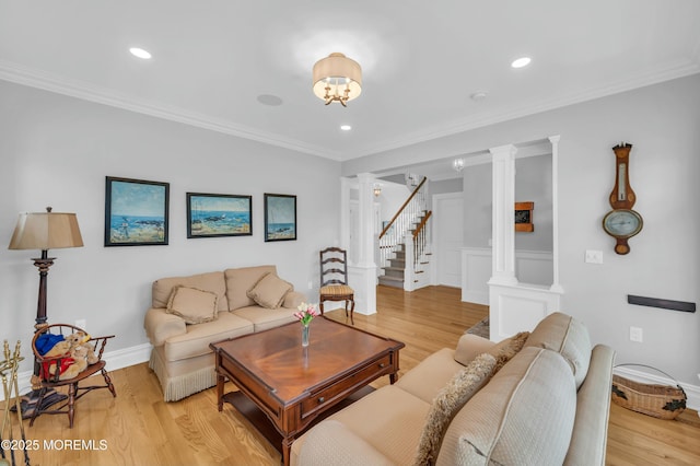 living area with recessed lighting, light wood-style flooring, decorative columns, and stairway
