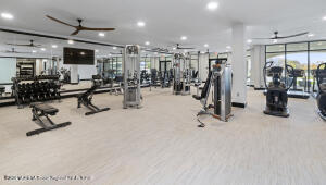 exercise room featuring a wall of windows, a ceiling fan, and recessed lighting