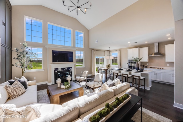 living area with dark wood-style flooring, a notable chandelier, and a healthy amount of sunlight