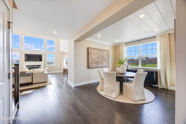 dining room featuring dark wood-type flooring, baseboards, a fireplace, and recessed lighting