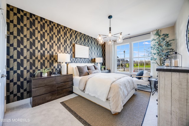carpeted bedroom with an accent wall, a chandelier, wallpapered walls, and visible vents