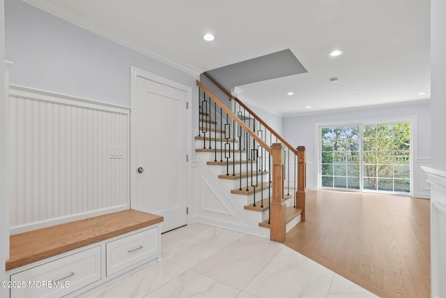 stairs featuring recessed lighting, crown molding, and wainscoting
