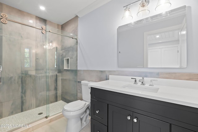 bathroom with toilet, tile walls, vanity, and a stall shower