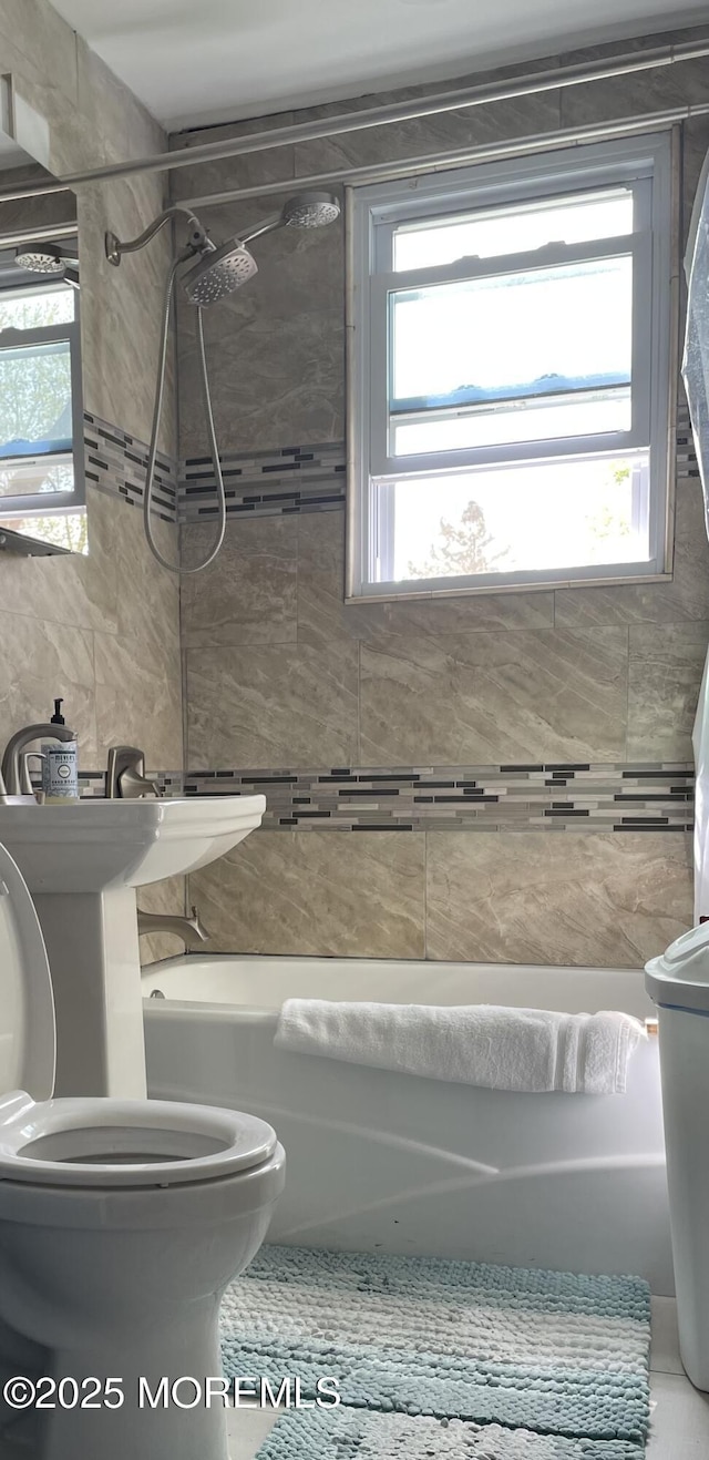 bathroom featuring tub / shower combination and toilet