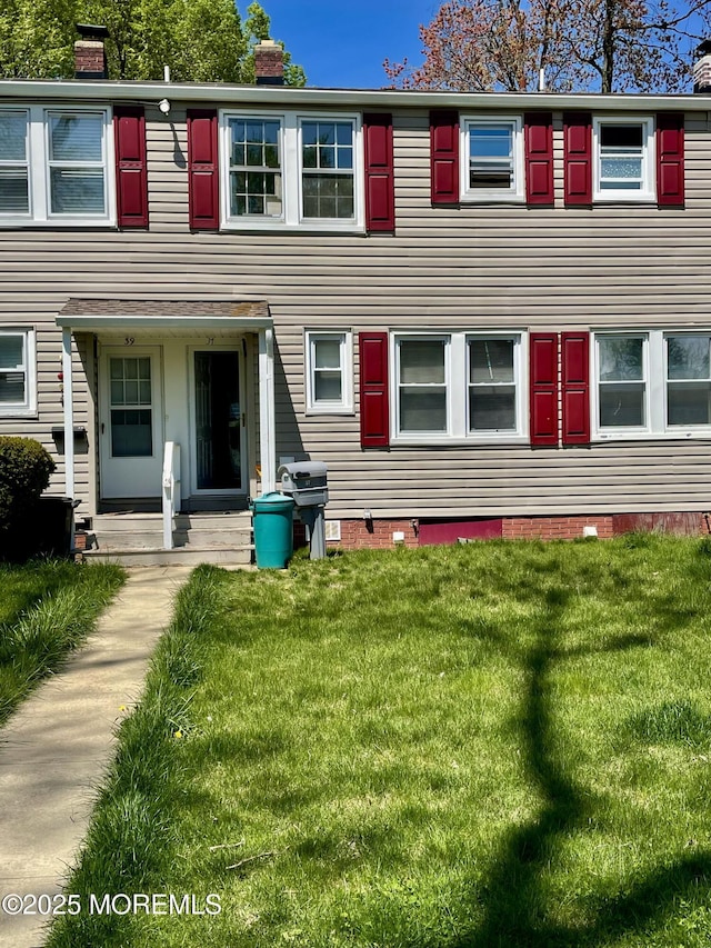 view of front of property featuring a chimney and a front yard