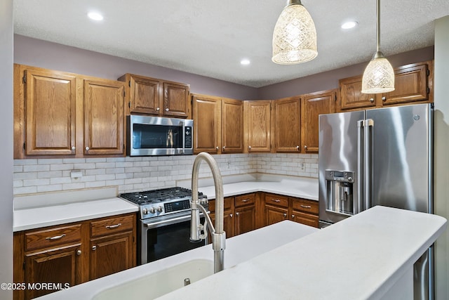 26 Dogwood Dr, Barnegat, NJ 08005 - kitchen with appliances with stainless steel finishes, light countertops, decorative light fixtures, brown cabinets, and backsplash