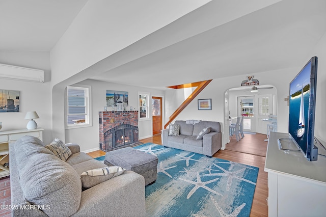 316 Rte 37, Seaside Heights, NJ 08751 - living area with a wall unit AC, a brick fireplace, ceiling fan, arched walkways, and wood finished floors
