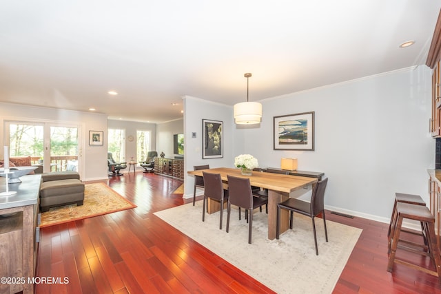 dining room featuring visible vents, ornamental molding, baseboards, and dark wood-type flooring
