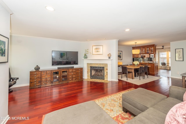 living room featuring recessed lighting, baseboards, a fireplace, and hardwood / wood-style floors