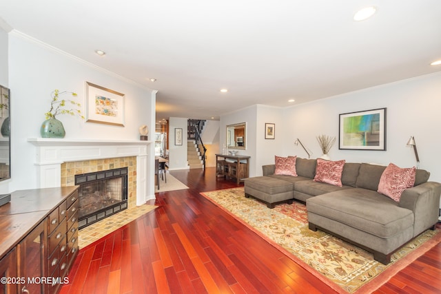 living area featuring crown molding, recessed lighting, and a tiled fireplace