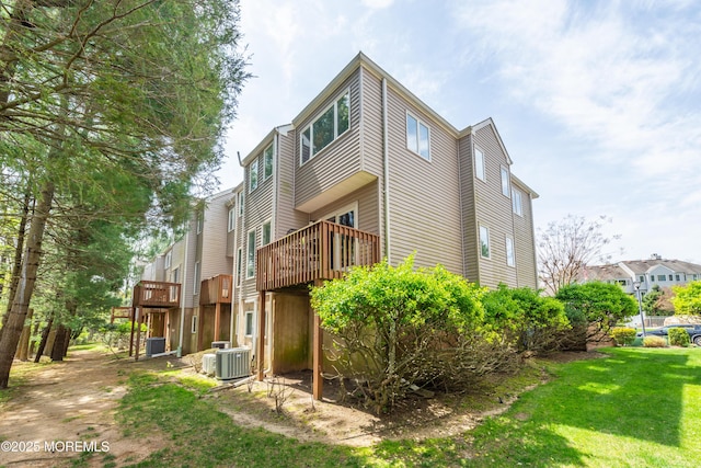exterior space featuring central AC, a yard, and a deck