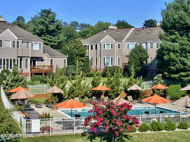 surrounding community with fence, a pool, and a patio