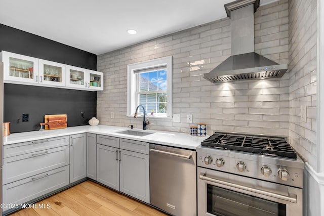 109 Capstan Ave, Beachwood, NJ 08722 - kitchen featuring stainless steel appliances, wall chimney exhaust hood, a sink, gray cabinetry, and decorative backsplash