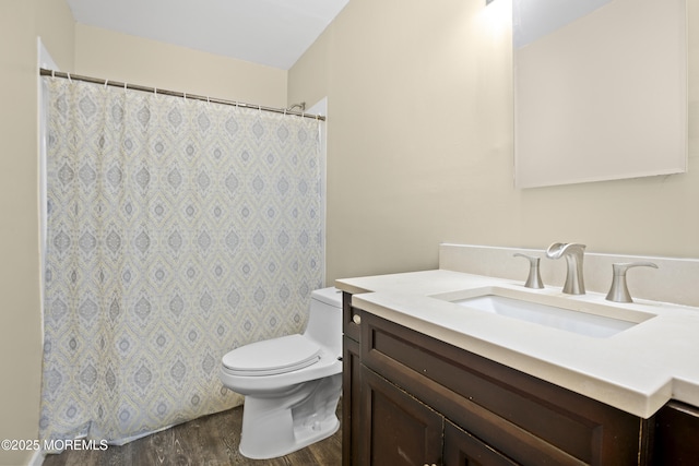 bathroom with wood finished floors, toilet, vanity, and a shower with curtain