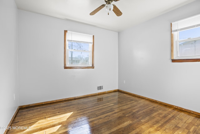 unfurnished room featuring hardwood / wood-style floors, plenty of natural light, and baseboards