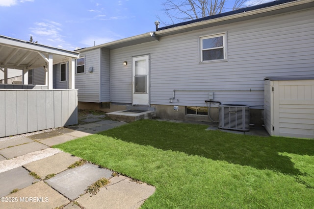 back of house with a yard and central AC