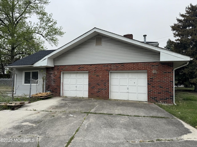 836 Radio Rd, Little Egg Harbor, NJ 08087 - view of side of property with concrete driveway, brick siding, a chimney, and an attached garage