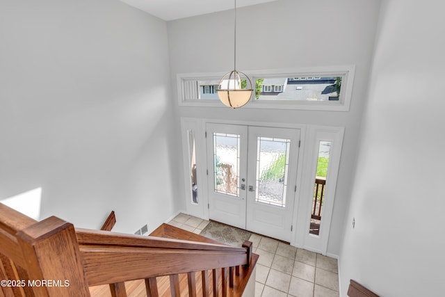 entryway with light tile patterned floors, a wealth of natural light, french doors, and visible vents