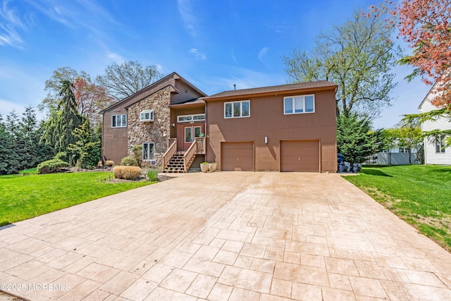 view of front of house with a front yard, a garage, stone siding, and decorative driveway