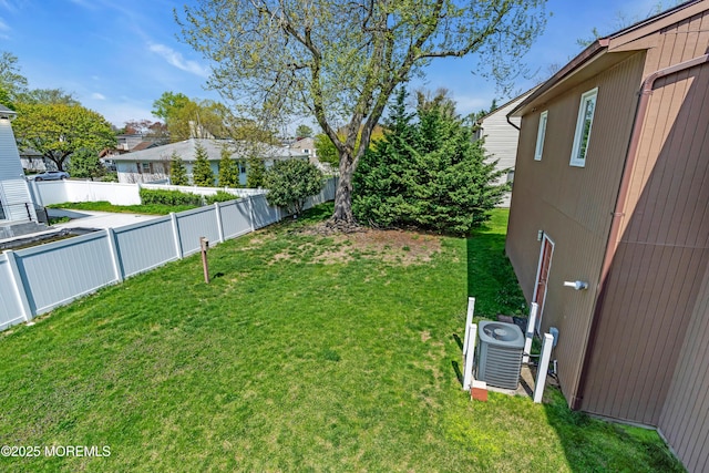view of yard with central air condition unit and a fenced backyard