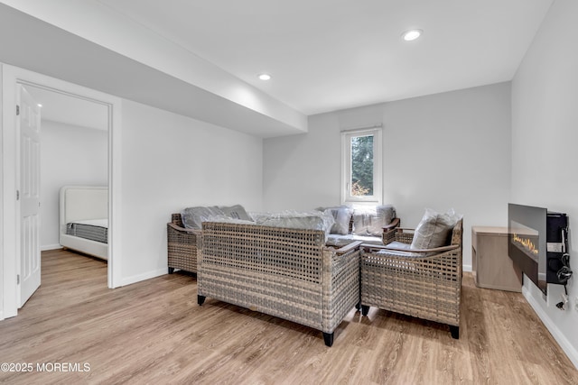 living area featuring baseboards, recessed lighting, and wood finished floors