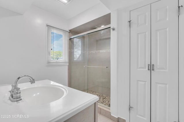bathroom featuring a sink, a closet, and a shower stall
