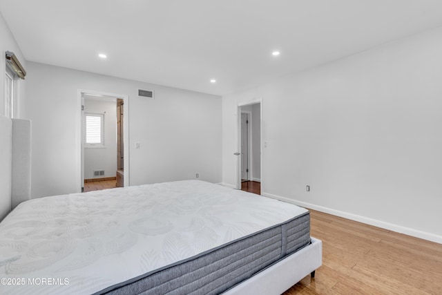 bedroom featuring wood finished floors, visible vents, and recessed lighting