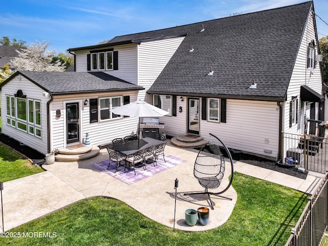 back of property with a yard, fence, a patio, entry steps, and roof with shingles