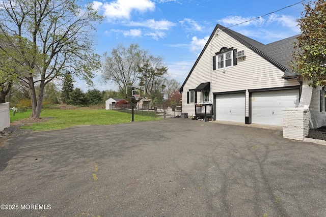 view of side of home featuring driveway, a yard, a garage, and roof with shingles