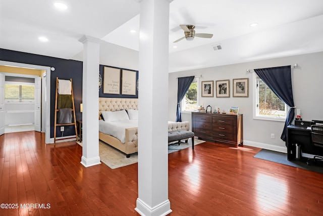 bedroom with visible vents, hardwood / wood-style flooring, baseboards, and decorative columns